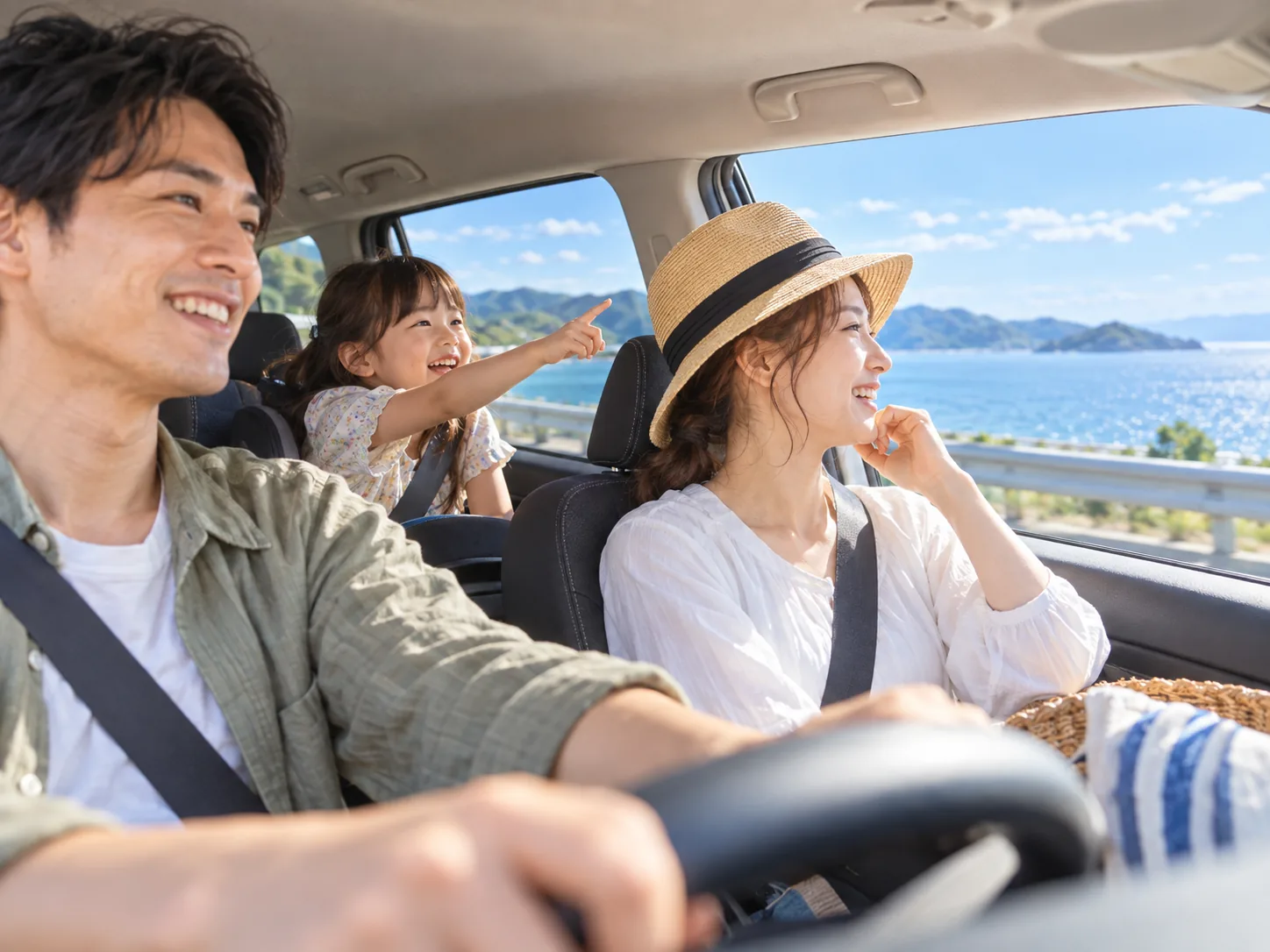 海を望む道を車で進む家族